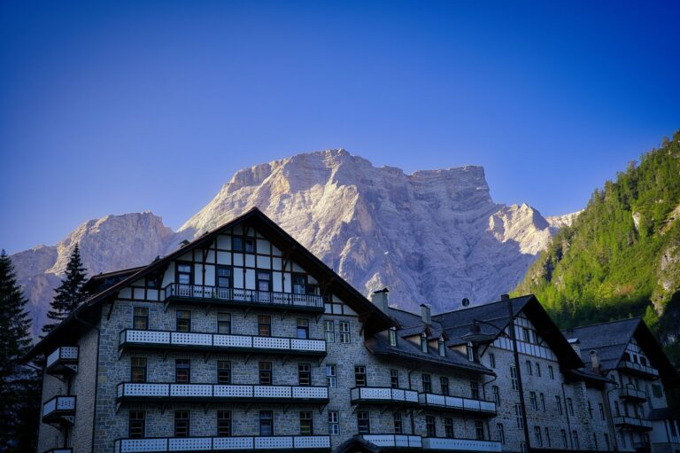Which Dolomites Hotels Have an Outdoor Pool and Panoramic Whirlpool? A striking view of traditional alpine architecture set against the majestic Dolomites in Dobbiaco, Italy