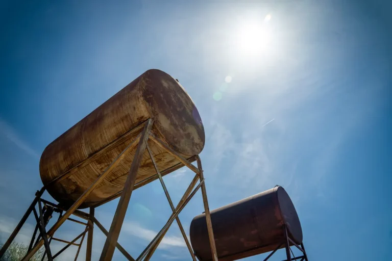 Heating oil customers face tough winter, minister says prices up 82% Rusty industrial oil tanks with a clear blue sky and bright sun